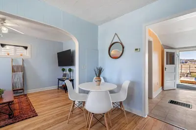a dining room with a white table and chairs at Dino Cave l Walk to Downtown l Fire Pit & BBQ I TV in Drumheller