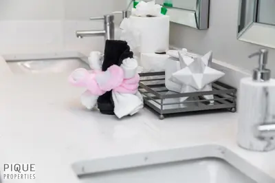 a bathroom counter with towels and toiletries on a sink at LUXURIOUS 6 Bed Home I Fireplace I near Sports Park I with Double Garage & Fast WiFi! in Edmonton
