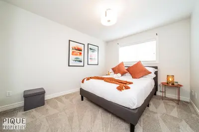 a white bedroom with a bed and a window at LUXURIOUS 6 Bed Home I Fireplace I near Sports Park I with Double Garage & Fast WiFi! in Edmonton