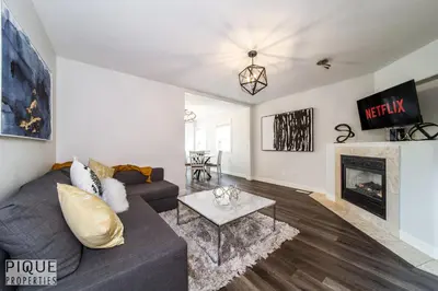 a living room with a couch and a fireplace at LUXURIOUS 6 Bed Home I Fireplace I near Sports Park I with Double Garage & Fast WiFi! in Edmonton