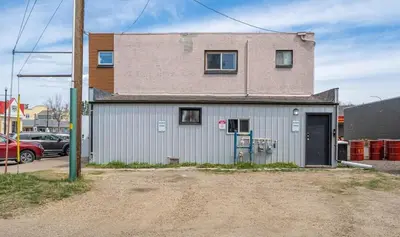 a gray building with a door in a parking lot at The Hidden Loft I 5-min Walk 2 Beach I DT I 55 TV in Sylvan Lake