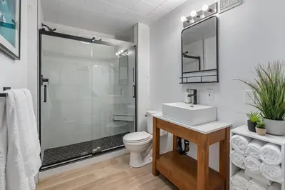 a bathroom with a shower and a sink and a toilet at The Hidden Loft I 5-min Walk 2 Beach I DT I 55 TV in Sylvan Lake