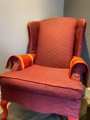 a red chair with an orange blanket on it at lovely home in Calgary