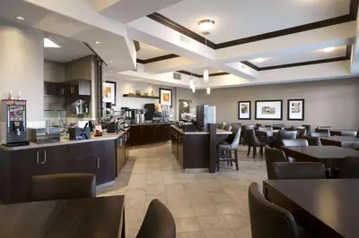a restaurant with tables and chairs and a cafeteria at Ramada by Wyndham Conklin in Conklin