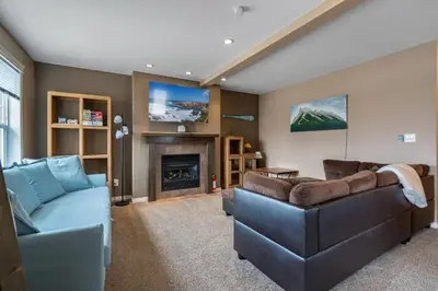 a living room with a couch and a fireplace at Prairie Oasis I Sleeps 16 l BBQ & Patio l Smart TV in Sylvan Lake