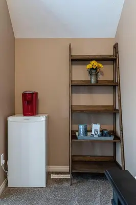 a shelf next to a refrigerator in a room at Prairie Oasis I Sleeps 16 l BBQ & Patio l Smart TV in Sylvan Lake