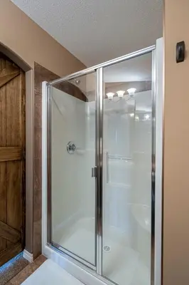 a glass shower stall in a bathroom at Prairie Oasis I Sleeps 16 l BBQ & Patio l Smart TV in Sylvan Lake
