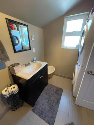 a bathroom with a sink and a refrigerator at Cozy loft in Upper Gibsons in Gibsons