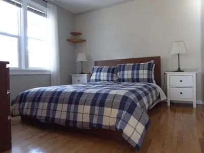 a bedroom with a bed with a blue and white plaid blanket at Banff Beaver Cabins in Banff