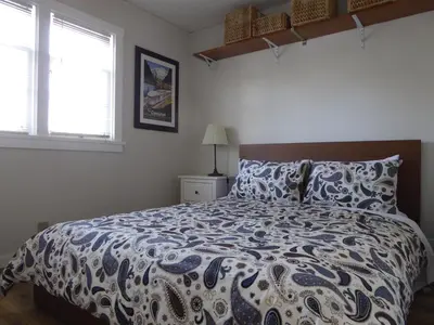 a bedroom with a bed with a blue and white comforter at Banff Beaver Cabins in Banff