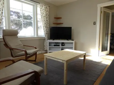 a living room with a tv and a table and a chair at Banff Beaver Cabins in Banff