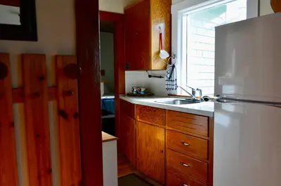 a kitchen with a white refrigerator and a sink at Banff Beaver Cabins in Banff