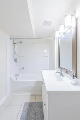 a white bathroom with a sink and a mirror at UofC-SAIT-Banff Trail-Suite A&B in Calgary