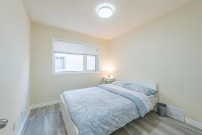 a white bedroom with a bed and a window at UofC-SAIT-Banff Trail-Suite A&B in Calgary
