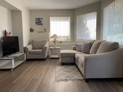 a living room with a couch and a television at Spacious and quiet garden view room in Kelowna