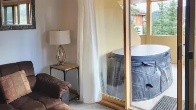 a living room with a large tub in the corner at Snow Creek Village #49 in Sun Peaks