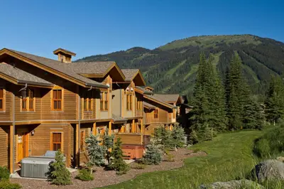 a log home with a mountain in the background at Woodhaven #19 by Bear Country in Sun Peaks