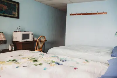 a bedroom with two beds and a microwave on a table at The Oceanfront Hotel in Sointula