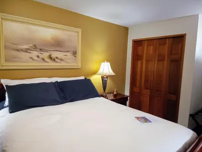 a bedroom with a bed and a painting on the wall at Hannie's Gasthuis in Blind Bay