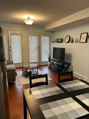 a living room with a television and a table at Lovely 1BR Secondary suite with Separate entrance in New Westminster