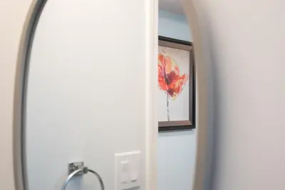 a mirror in a bathroom with a picture on the wall at Lovely 1BR Secondary suite with Separate entrance in New Westminster
