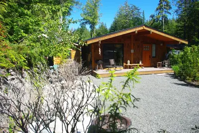 a log cabin with a porch and a patio at Wild Coast Chalets in Port Renfrew
