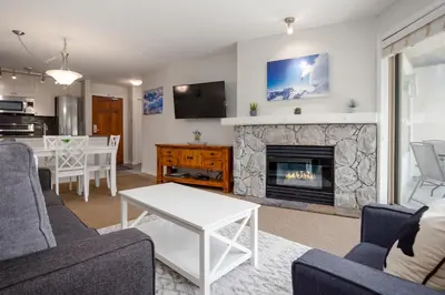 a living room with a couch and a fireplace at 1BR in The Aspens, King Bed, True Ski In, Ski Out, Hot Tubs and Pool, Ski Valet, Private Balcony in Whistler