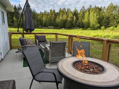 a patio with a table and chairs and a fire pit at The Cottage on the Farm in Ladysmith