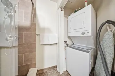 a bathroom with a shower and a washer and dryer at Newly renovated Blue Sky - Family Fun - 2 Bed -2 Bath in Canmore