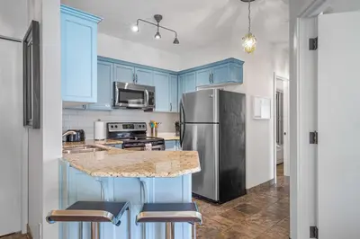 a kitchen with blue cabinets and a stainless steel refrigerator at Newly renovated Blue Sky - Family Fun - 2 Bed -2 Bath in Canmore
