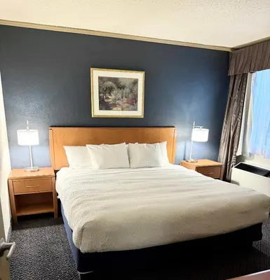 a large bed in a hotel room with two lamps at Days Inn by Wyndham Drayton Valley in Drayton Valley