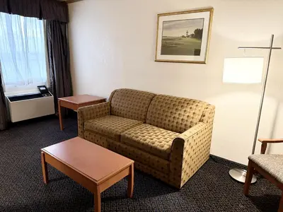 a living room with a couch in a hotel room at Days Inn by Wyndham Drayton Valley in Drayton Valley