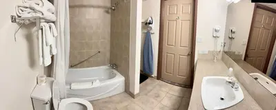 a bathroom with a tub and a toilet and a sink at Days Inn by Wyndham Drayton Valley in Drayton Valley