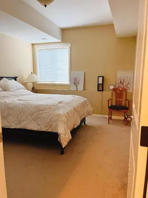 a bedroom with a large bed and a window at 1 bedroom lake Mountain view in West Kelowna