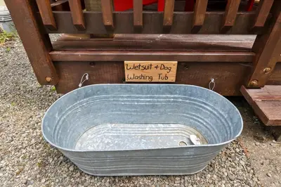a large blue tub sitting on the ground next to a bench at Bear Coast, Cabin with Hot Tub, Patio, and Waterview in Ucluelet
