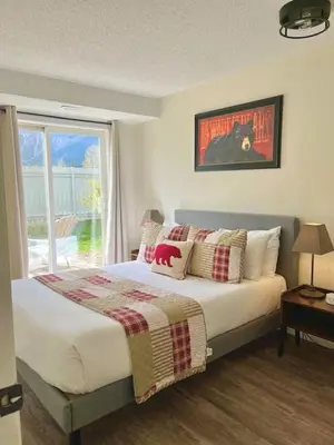 a bedroom with a bed with pillows and a window at Nakiska, 2 Bed 1 Bath with Mtn Views in Canmore