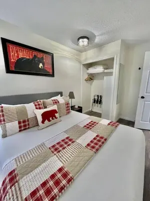 a bedroom with a bed with a red and white blanket at Nakiska, 2 Bed 1 Bath with Mtn Views in Canmore