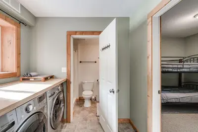 a laundry room with a washing machine and a bunk bed at Whiskey Jack, 4 Bedroom Cabin with Outdoor Firepit in Sunshine Valley