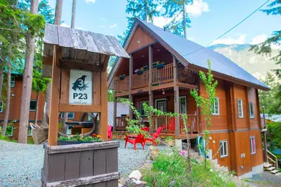 a large wooden house with a sign in front of it at Whiskey Jack, 4 Bedroom Cabin with Outdoor Firepit in Sunshine Valley