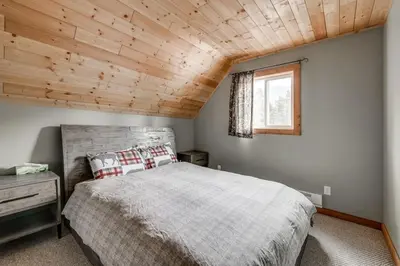 a bedroom with a bed and a wooden ceiling at Whiskey Jack, 4 Bedroom Cabin with Outdoor Firepit in Sunshine Valley