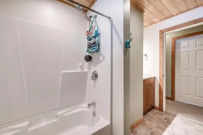 a bathroom with a white tub and a sink at Whiskey Jack, 4 Bedroom Cabin with Outdoor Firepit in Sunshine Valley