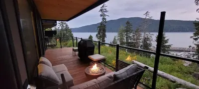a screened in porch with a view of a lake at Halibut Hideaway in Port Renfrew