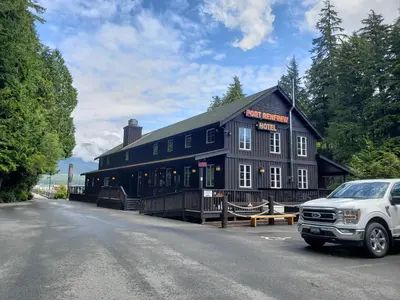 a black building with a car parked in front of it at Halibut Hideaway in Port Renfrew