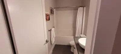a white bathroom with a toilet and a sink at Halibut Hideaway in Port Renfrew