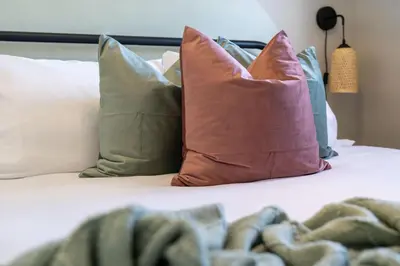 a bed with several pillows on top of it at The Saturday I Perfect for Families I Arcade Games in Sylvan Lake