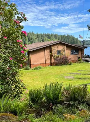 a house in a yard with a green lawn at April Point Harbour House in Quathiaski Cove