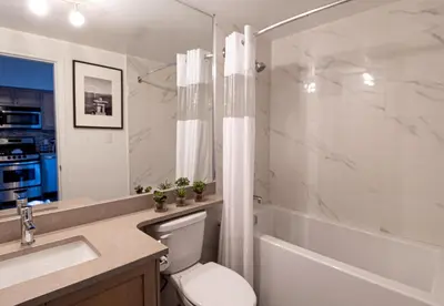 a bathroom with a toilet and a sink and a bathtub at Alpenglow Lodge Fika One Bedroom by MVA in Whistler