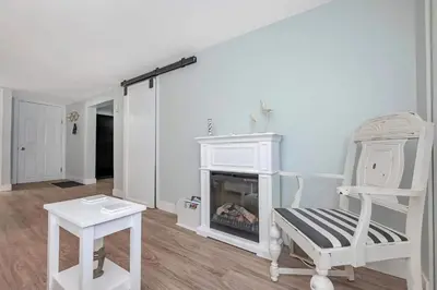 a living room with a chair and a fireplace at Quaint 1 bedroom lower suite in Victoria, BC in Victoria