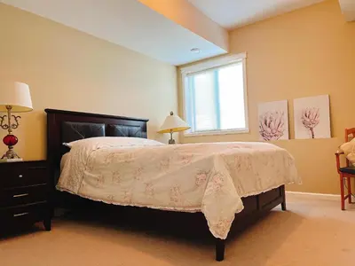 a bedroom with a bed and a window at Peaceful and Spacious Lake View in West Kelowna