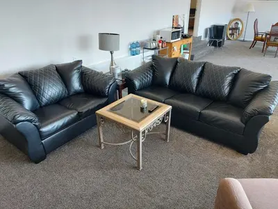 a black leather couch and a coffee table in a living room at Peaceful and Spacious Lake View in West Kelowna
